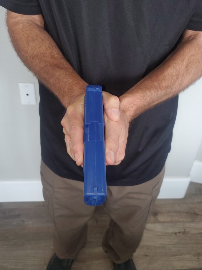 Person holding a blue training pistol.
